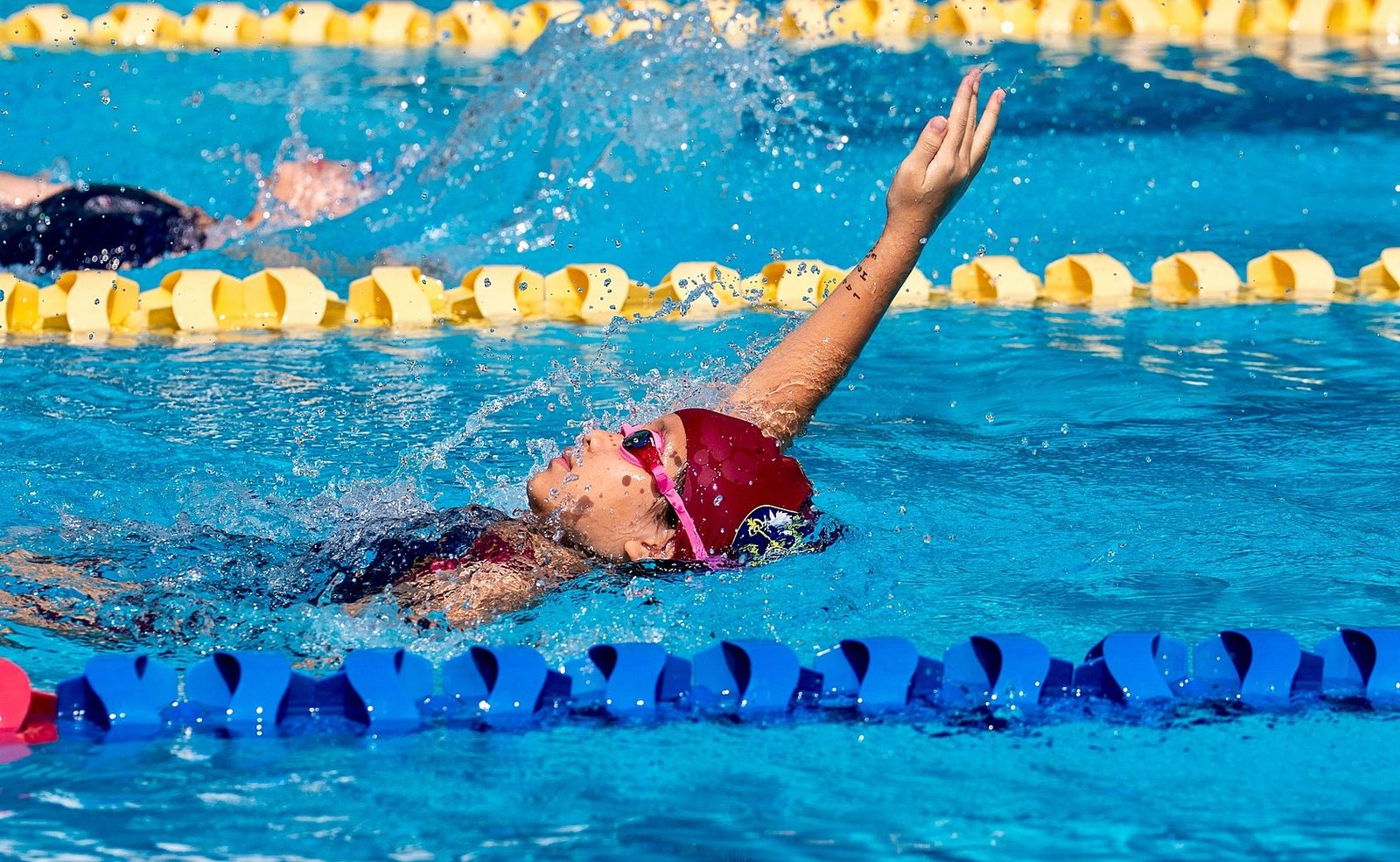 Young swimmer training in backstroke